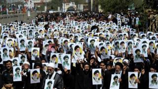Shia Muslims in Karachi hold posters of Iran's new supreme leader Mojtaba Khamenei alongside the late Iranian supreme leader Ali Khamenei.