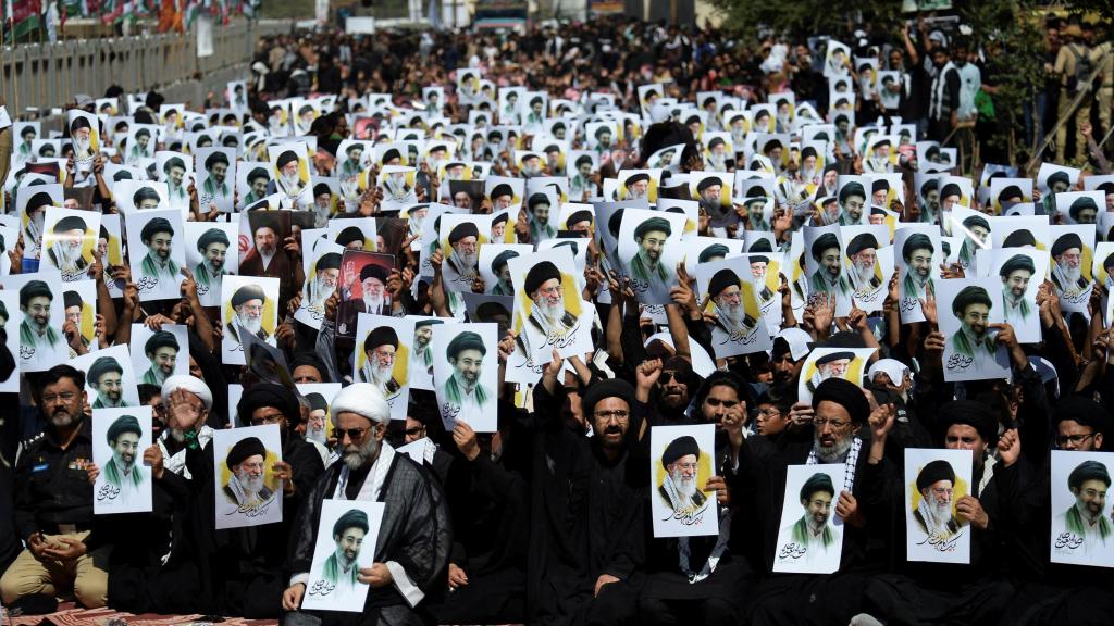 Musulmanes chiíes de Karachi sostienen carteles del nuevo líder supremo de Irán, Mojtaba Jamenei, junto al difunto líder supremo iraní, Alí Jamenei.