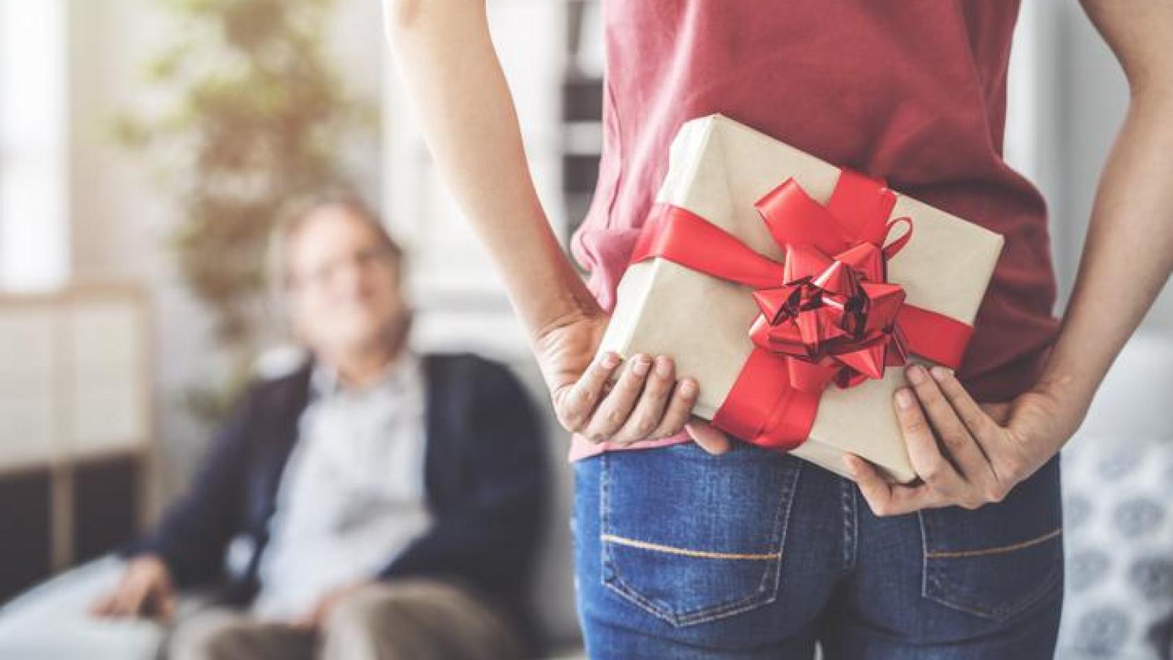 Joven llevando un regalo a sus espaldas por el Día del Padre