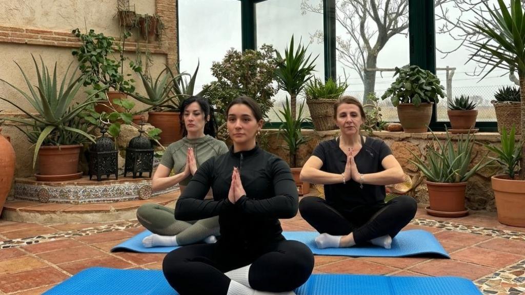 Tres mujeres practicando yoga en La Yucca.