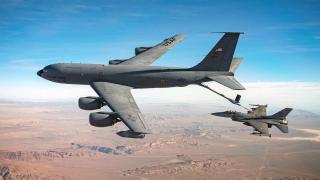 A US Air Force KC-135 tanker aircraft refueling an F-16 fighter in flight.