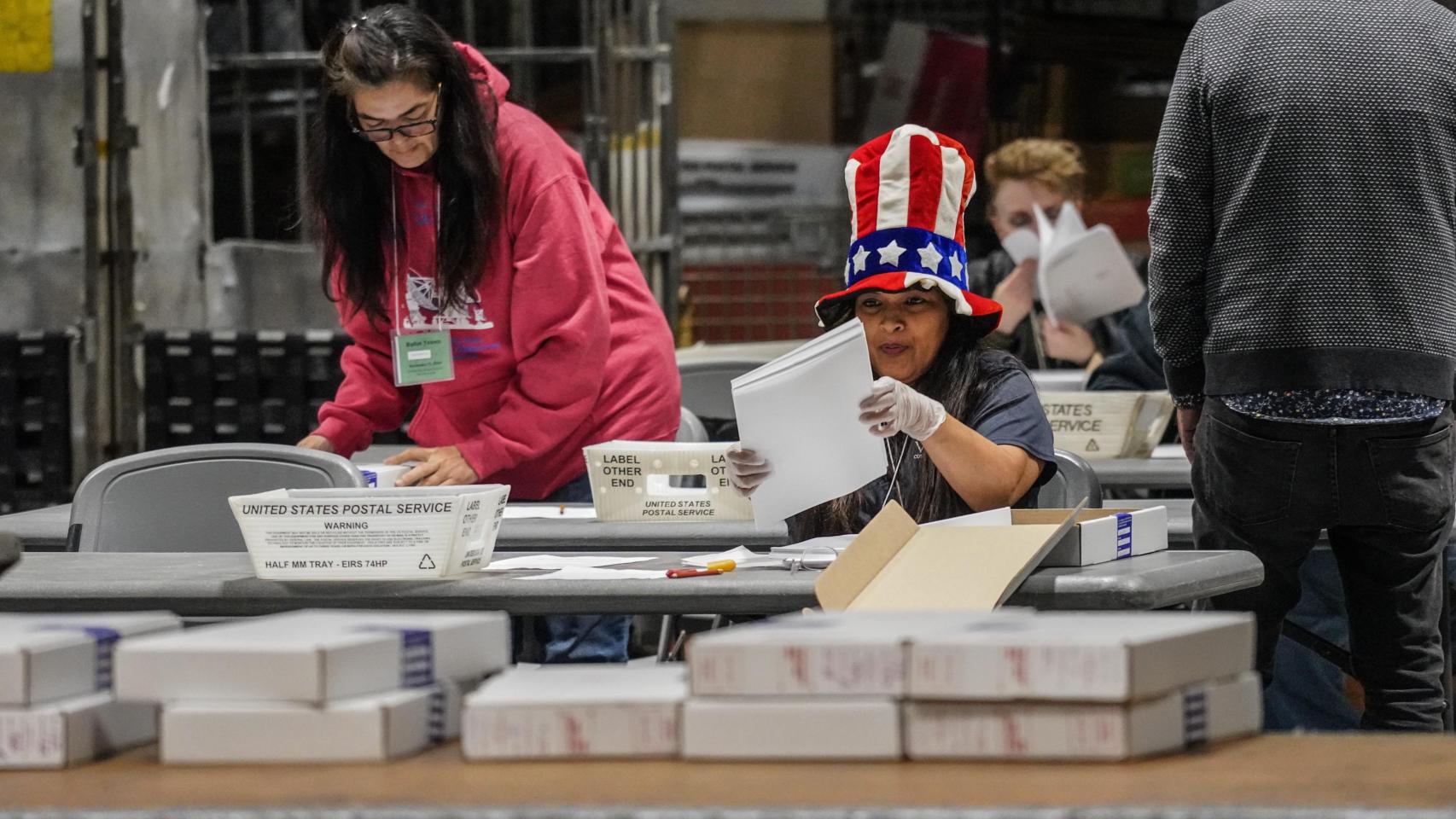 Trabajadoras del Registro de Votantes procesan votos por correo en EEUU para las elecciones de 2024.
