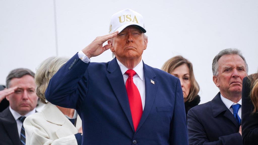 El presidente estadounidense Donald Trump saluda durante el solemne traslado de los restos de seis miembros del Ejército de EE. UU. del 103.er Comando de Apoyo Logístico, fallecidos en Kuwait.
