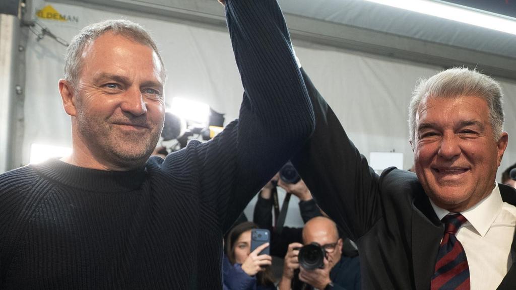 Joan Laporta alza su mano con Hansi Flick.