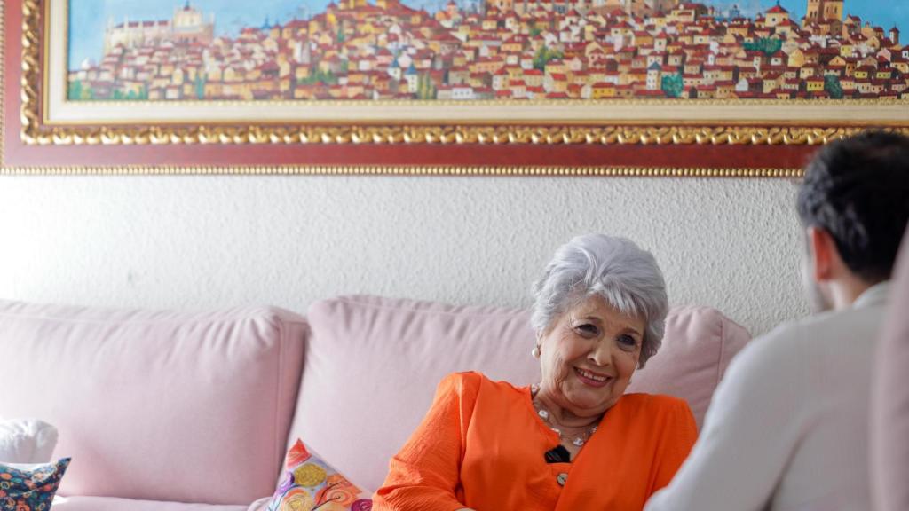 Primer plano de María Sánchez-Biezma y encima uno de sus cuadros de la ciudad de Toledo.