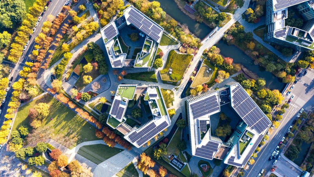 Vista aérea de un edificio moderno con equipos de generación de energía solar instalados en el tejado.