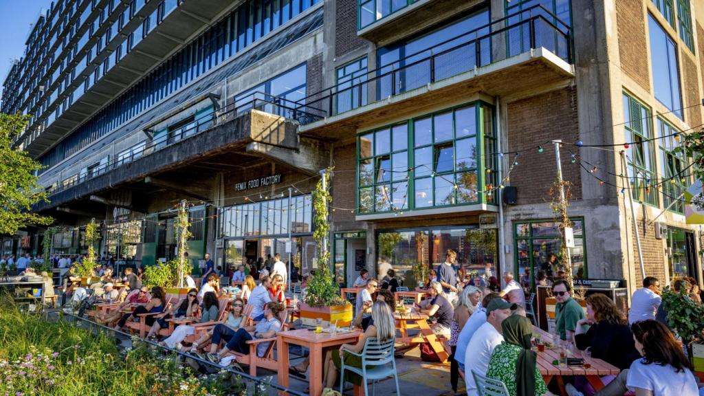 El Fenix Food Factory, con la terraza llena, junto al río en Róterdam.