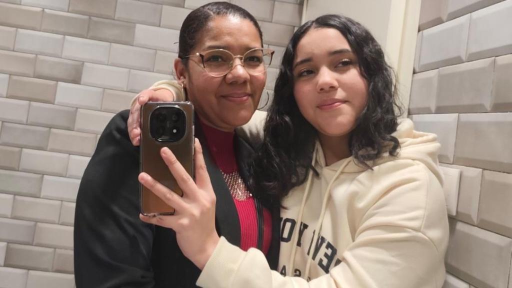 Lizeth, sonriente, posa abrazada a su difunta hija, Jaccely, para la que busca fondos para repatriar sus cenizas a Honduras.