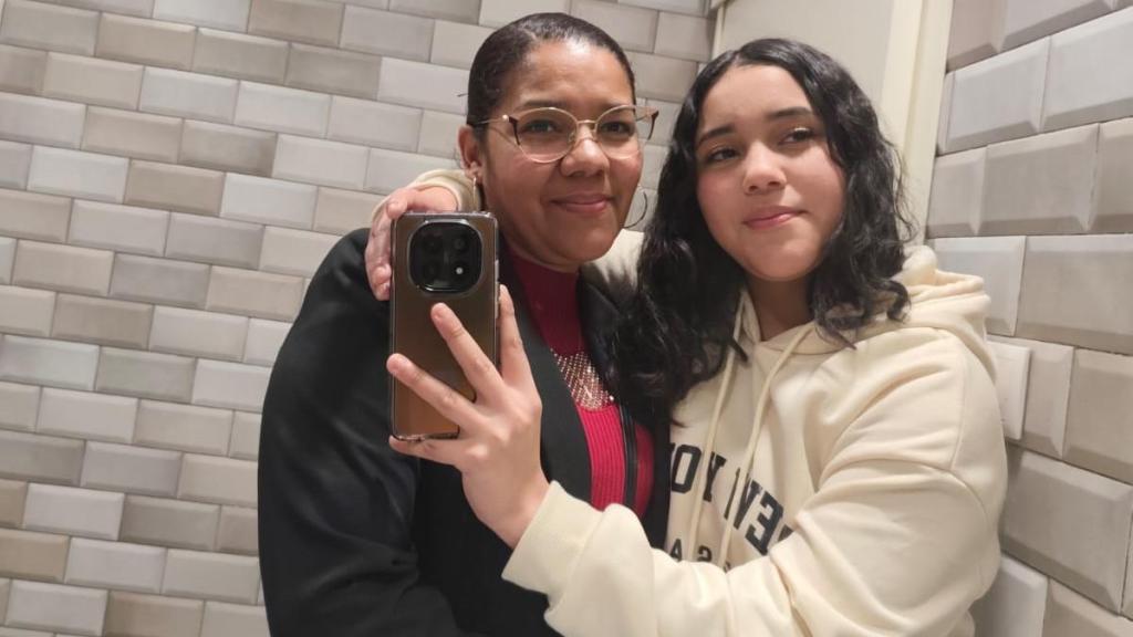 Lizeth, sonriente, posa abrazada a su difunta hija, Jaccely, para la que busca fondos para repatriar sus cenizas a Honduras.