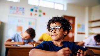 Niño sentado en un aula.