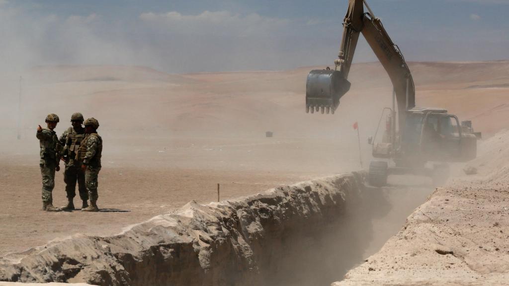 Miembros del Ejército de Chile supervisan la zanja que ha ordenado construir Kast en el norte de la frontera.