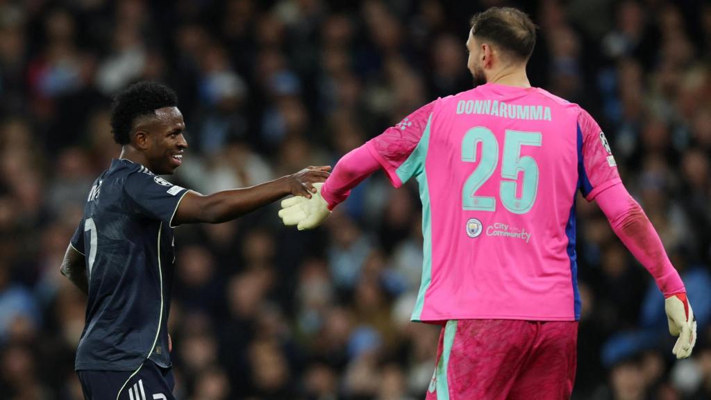 Vinicius y Donnarumma chocan sus manos en señal de deportividad.