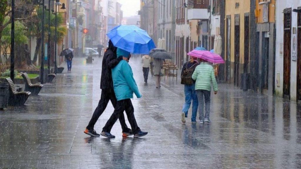 Personas caminando con paragüas.