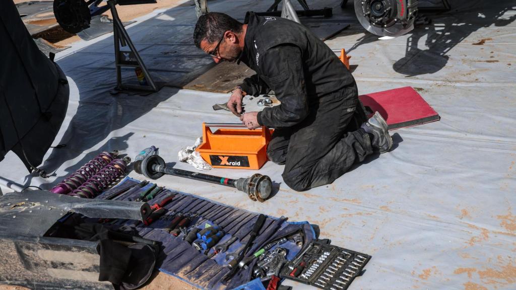 Imagen de un mecánico arreglando distintas piezas.