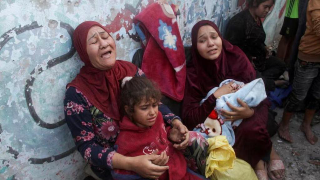 Dos mujeres palestinas y una niña después de que una escuela que albergaba a personas desplazadas fuera alcanzada por un ataque israelí.