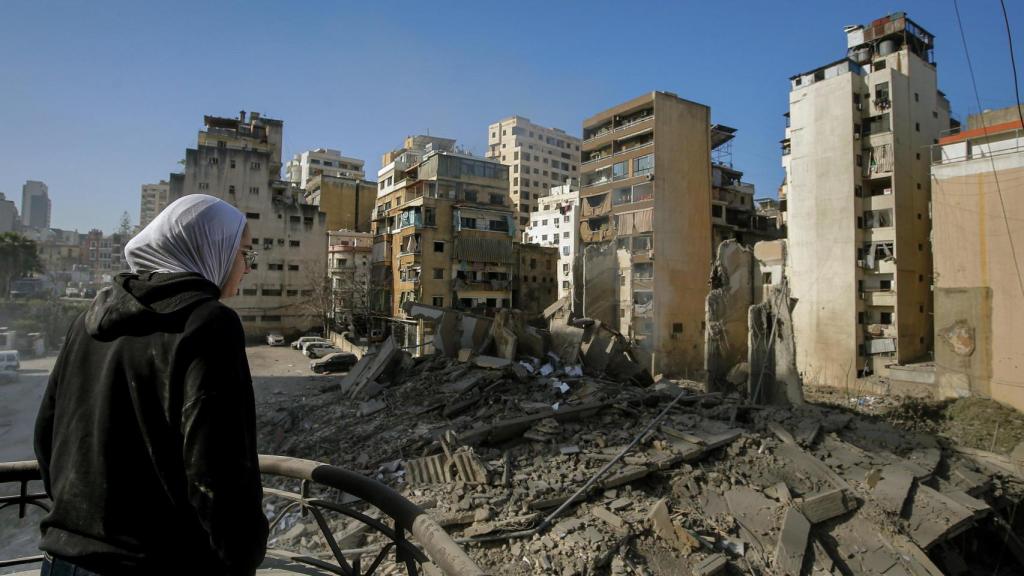 A woman looks at bombed buildings in Beirut. Marwan Naamani / dpa
