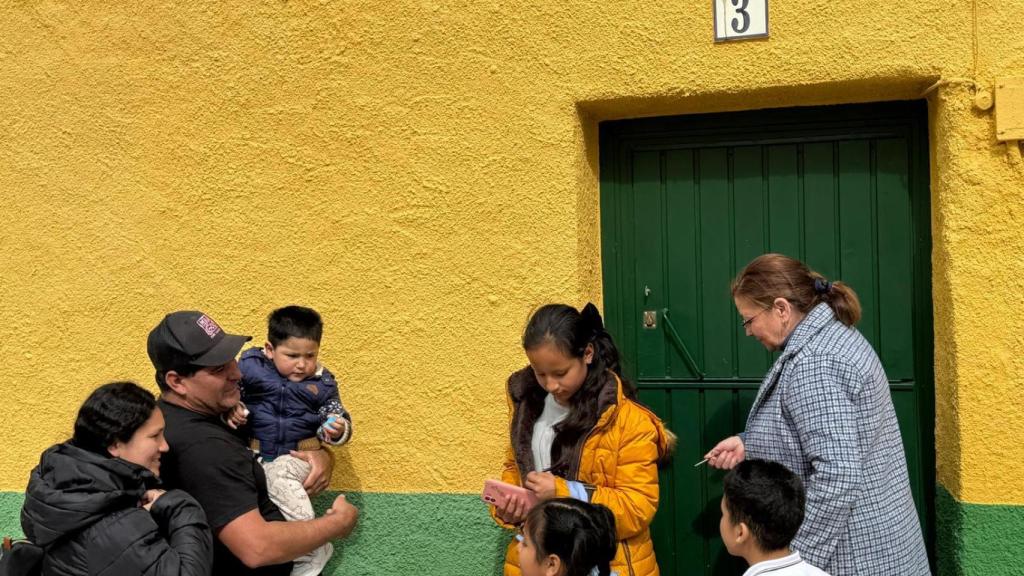 La propietaria de la vivienda junto a la familia peruana en la entrada de la vivienda en Alcañizo.