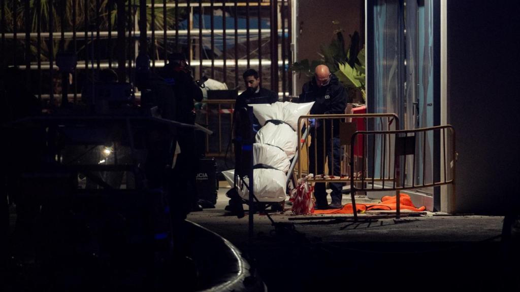 Dos agentes funerarios trasladan el cadáver de Gracey, tras su aparición a cuatro metros bajo el mar.