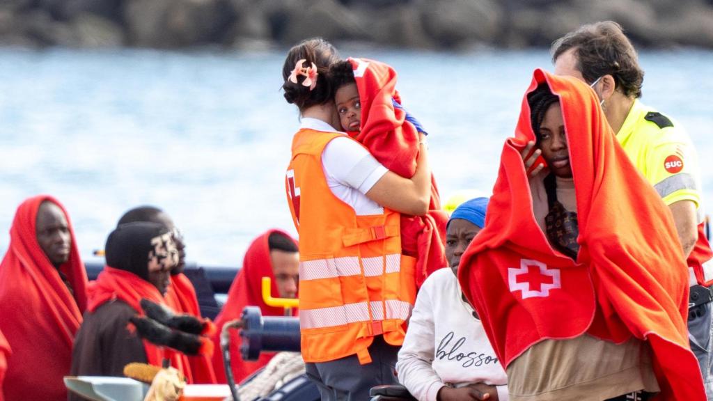 Agentes de emergencia atienden a los 60 migrantes, muchos de ellos menores, llegados en patera al muelle de Arrecife, en Lanzarote (Canarias).