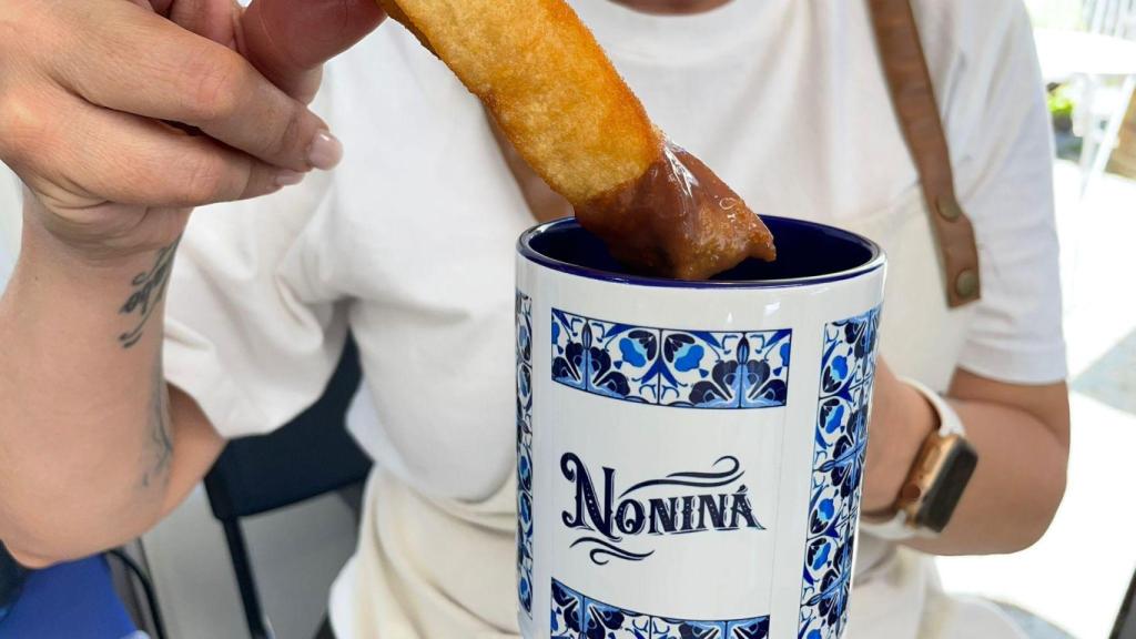 Un churro con chocolate.