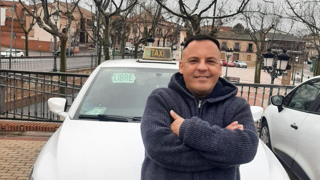 Óscar, este viernes, sentado en el capó de su taxi en Madrid.