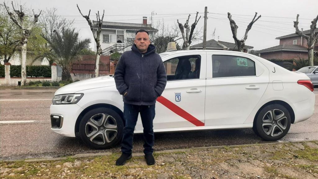 Óscar, posando al lado de su taxi.