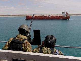 U.S. Navy sailors conduct surveillance from a gangplank of the aircraft carrier USS Gerald R. Ford as it transits the Suez Canal.