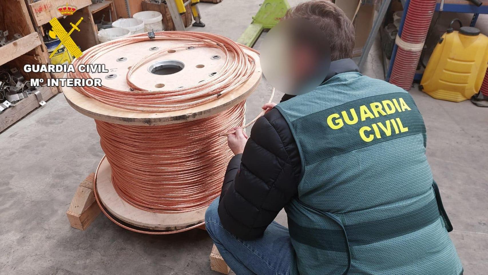 Un agente de la Guardia Civil con una de las bobinas de cableado de cobre recuperadas en León