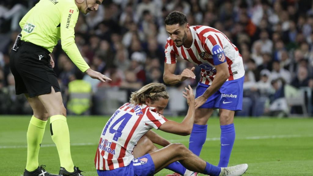 Koke helps Marcos Llorente after suffering a blow during the derby