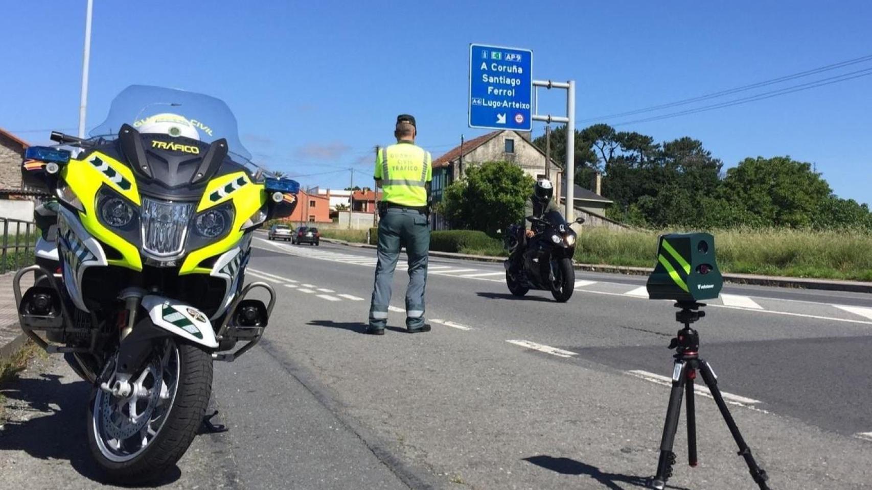 Un Guardia Civil de Tráfico junto a un radar en una carretera.