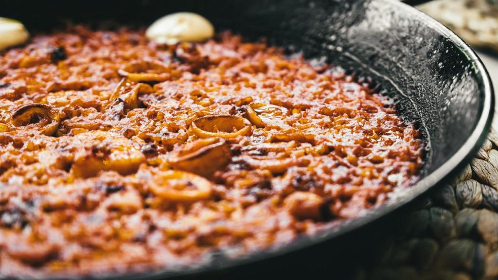 Paella casera en sartén de hierro.
