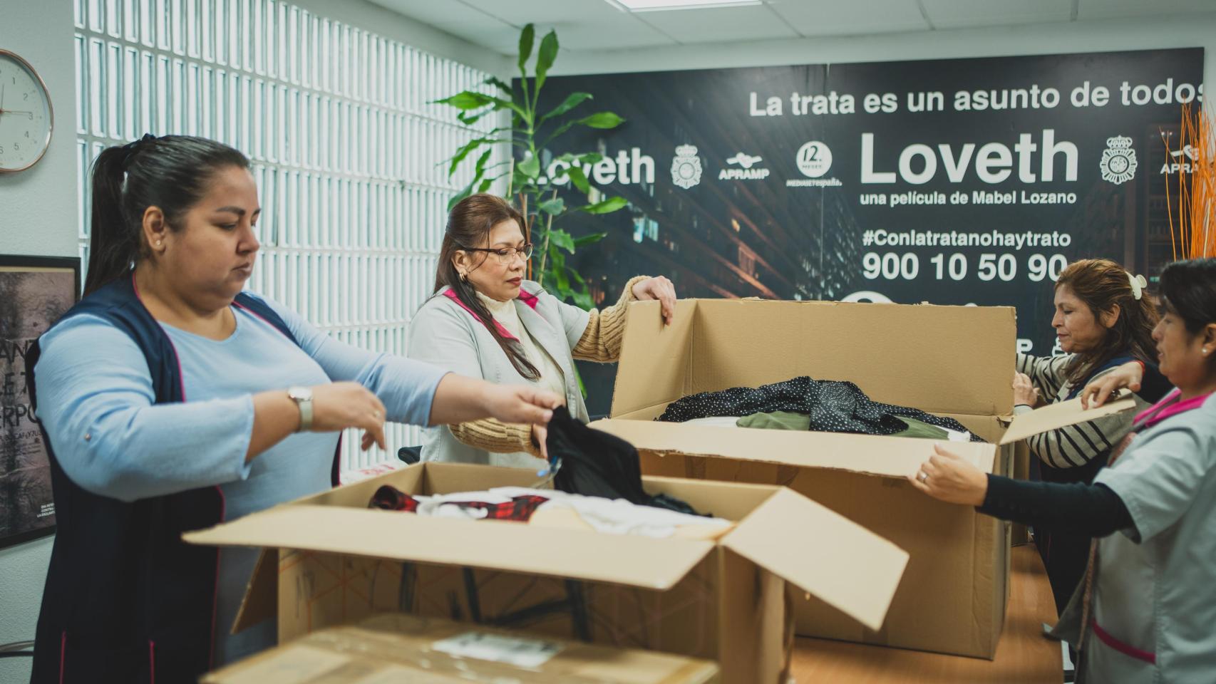 Trabajadoras de APRAMP recibiendo abriendo las cajas de las prendas de la 'swap party' de Magas y Enclave ODS.