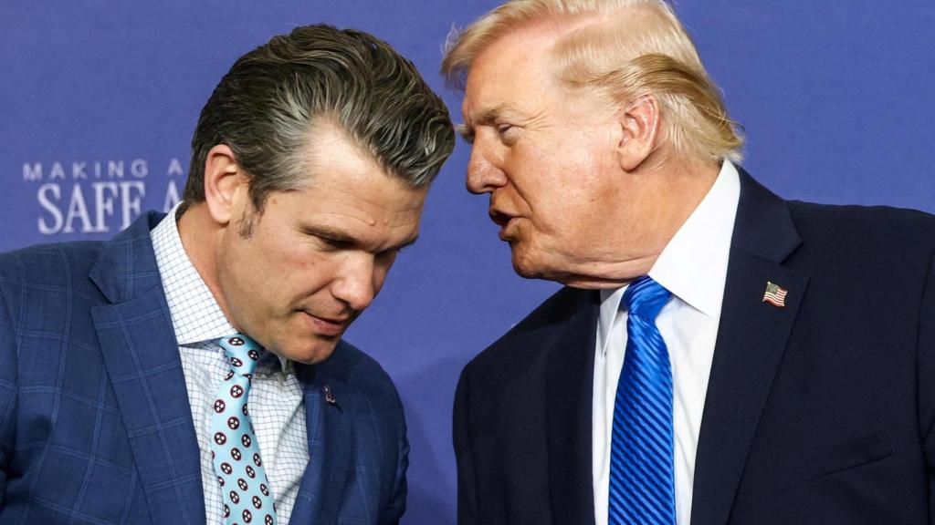 Donald Trump habla con su secretario de Defensa, Pete Hegseth, en la base de la Guardia Aérea Nacional de Memphis.