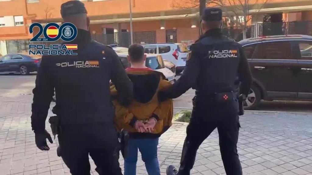 Dos agentes custodian al detenido tras su arresto en Madrid.