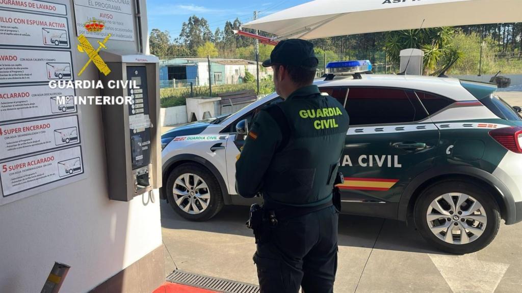 Imagen de archivo de un agente de la Guardia Civil al lado de un coche