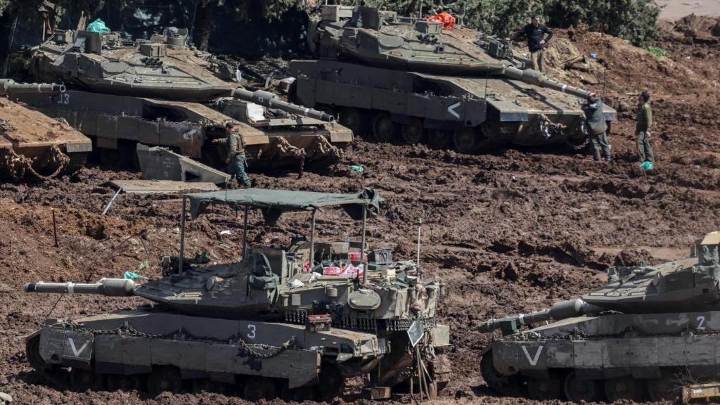 Soldados israelíes se encuentran junto a tanques en el lado israelí de la frontera con Líbano , en el norte de Israel.Soldados israelíes se encuentran junto a tanques en el lado israelí de la frontera con Líbano, en el norte de Israel.