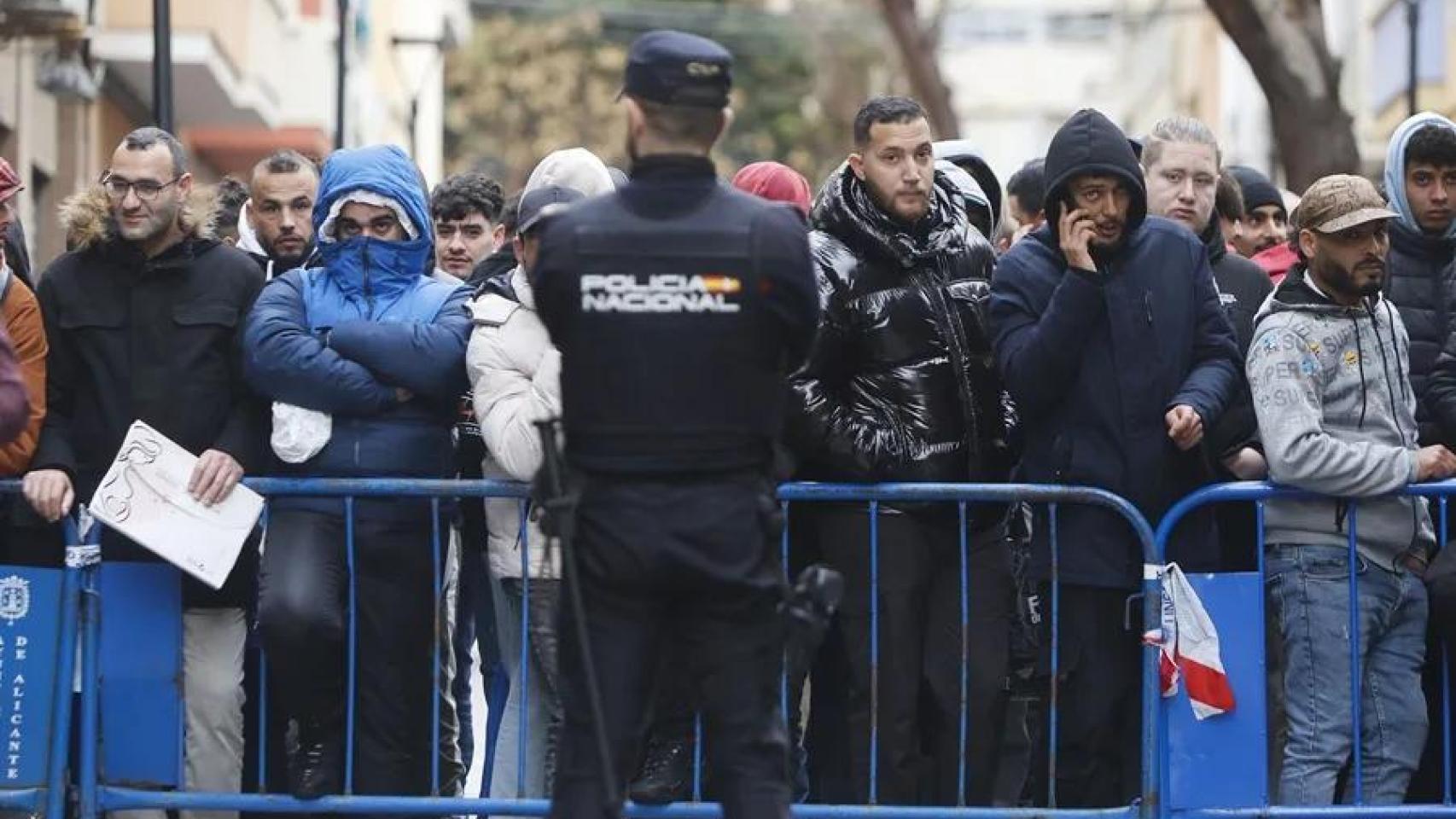 Inmigrantes argelinos hacen cola ante su consulado en Alicante en busca de documentación para la regularización masiva.