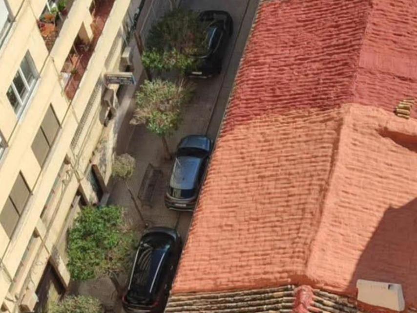 Coches policiales en un callejón frente al centro de acogida durante la operación de detención el pasado martes.