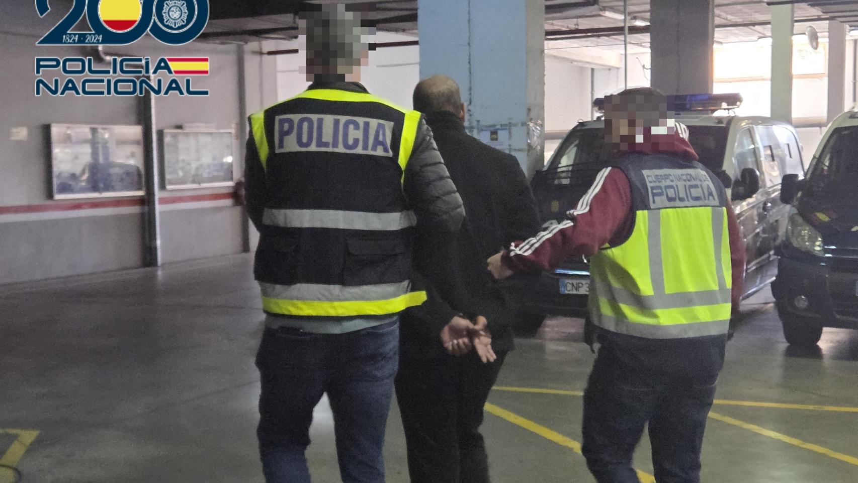 Imagen de dos agentes de la Policía Nacional trasladando al detenido.