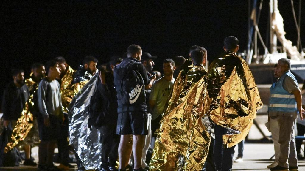 Un grupo de migrantes con mantas térmicas interceptado por la guardia costera italiana.