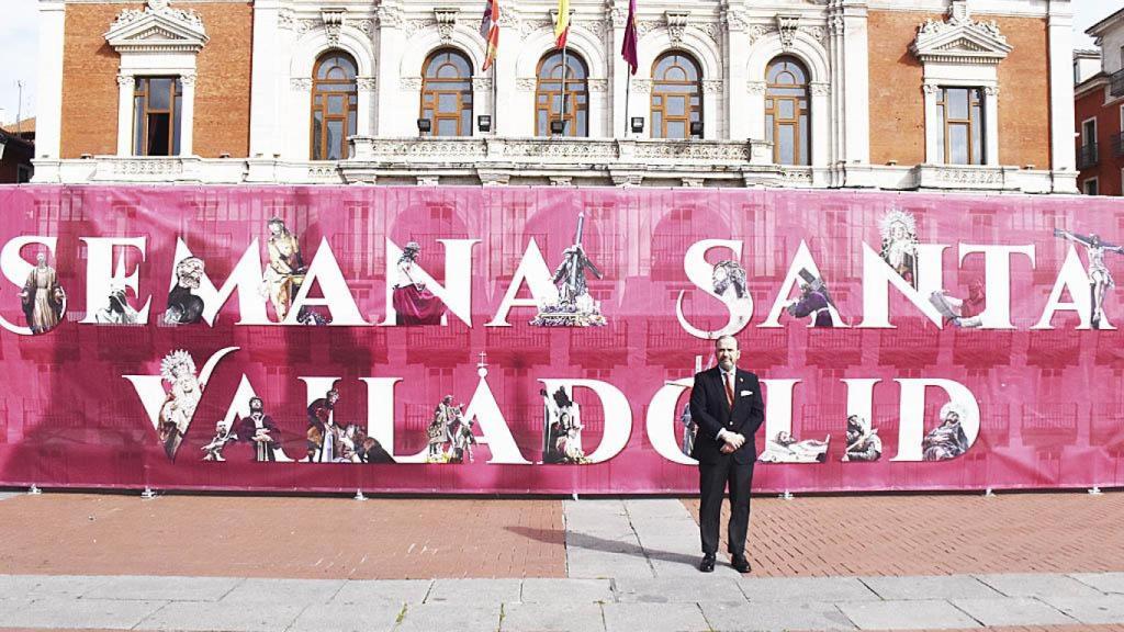 Miguel Vegas con el cartel de la Semana Santa de Valladolid en la Plaza Mayor.