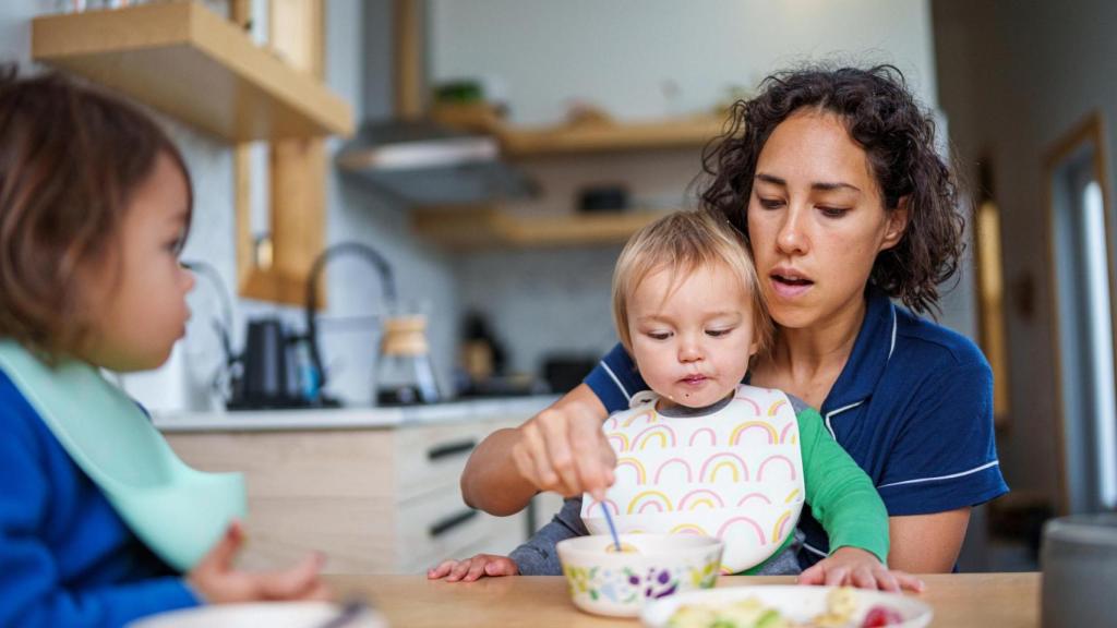 Una madre alimentando a sus hijos.