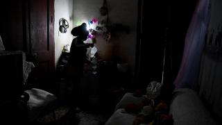 A Havana resident refills a drinking water bottle in the middle of a blackout.