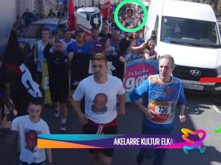El rostro de los asesinos del exalcalde Tomás Caballero, Patxi Ruiz y Alberto Viedma, en las camisetas que visten el niño y el adulto en la Korrika a su paso por Pamplona.