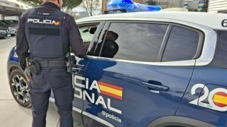 Un agente y un coche de la Policía Nacional