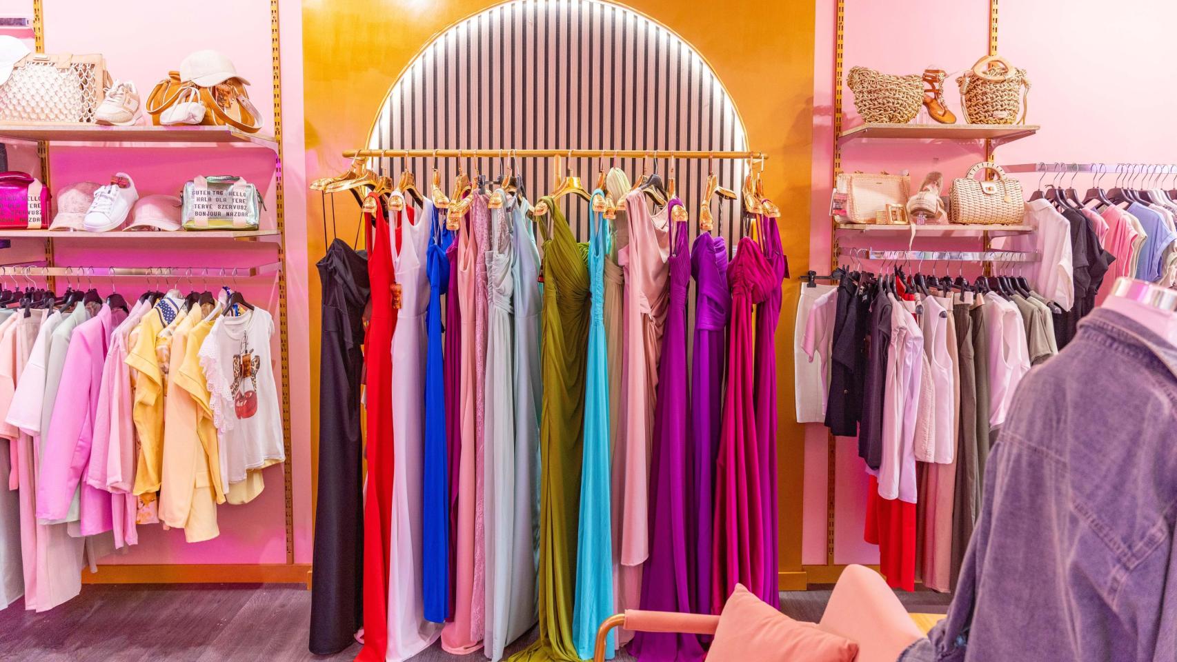 Distintas prendas de ropa en una tienda de moda femenina.