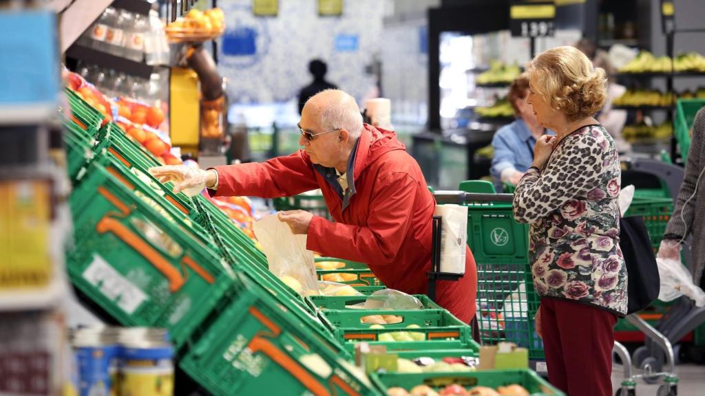 Dos personas comprando fruta en un supermercado Mercadona.