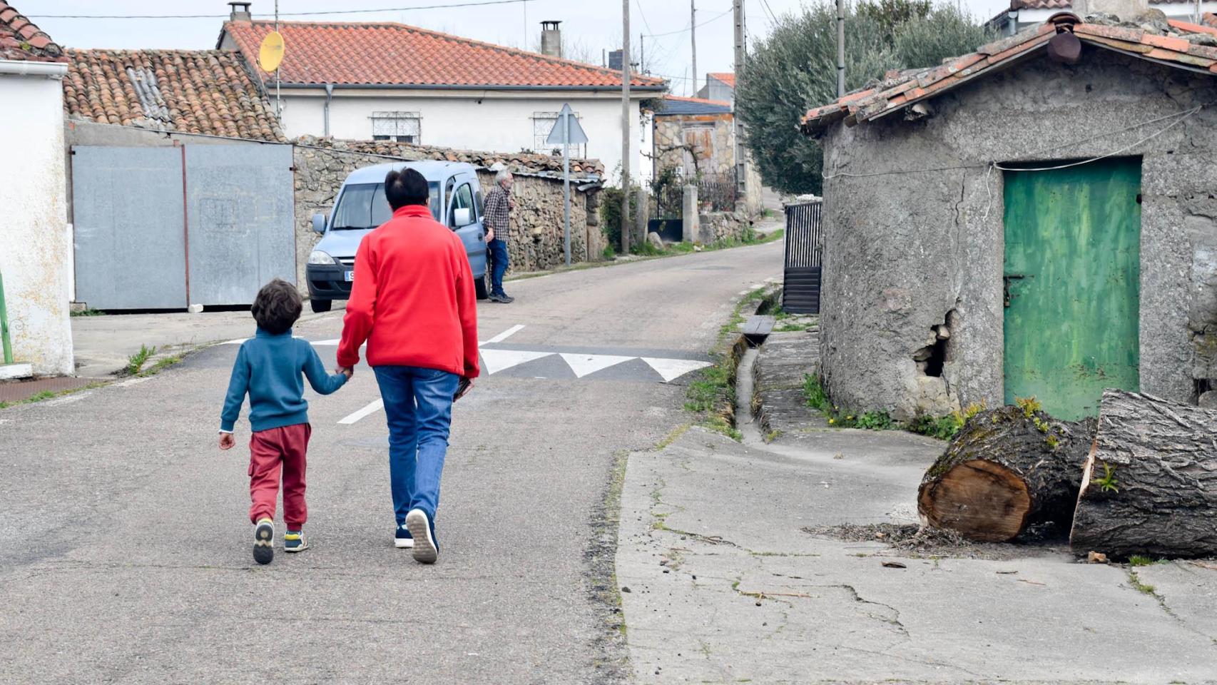 Una abuela con su nieto, vuelven a casa después de ir a buscar el pan al panadero ambulante en Brincones (Salamanca).