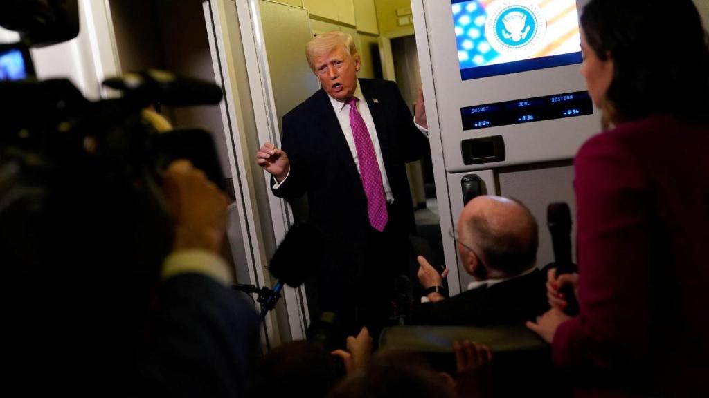 El presidente Donald Trump contesta a la prensa en el Air Force One.