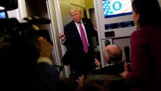 President Donald Trump answers the press on Air Force One.
